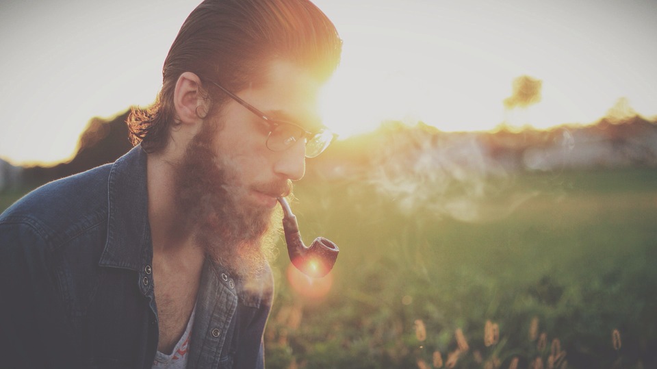 Man in a field smoking a pipe
